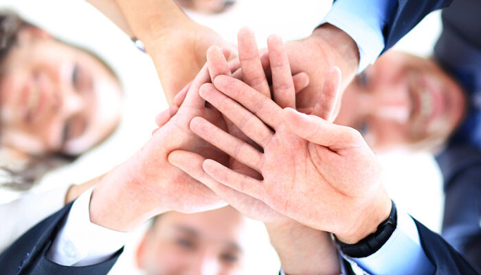 Mitarbeiter legen im Teamwork Ihre Hände zusammen