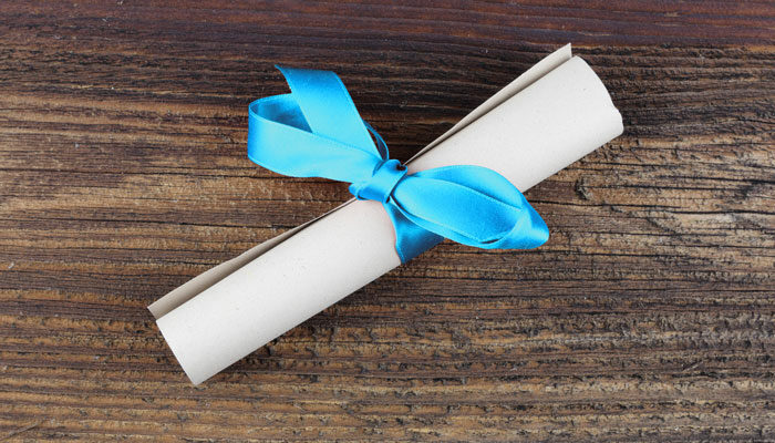 Ein zusammengerolltes Blatt Papier mit blauer Geschenkschleife